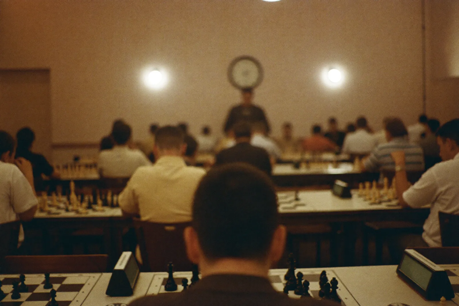 Une salle de tournoi vue de l'arrière, rangées de tables et de pendules
